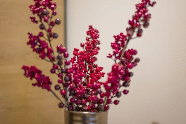 Rote Blütenzweige in einer Metallvase