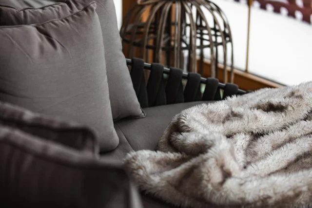 Gemütliches Sofa mit Kissen und einer Decke.