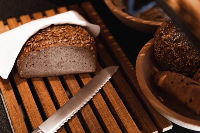 Frisches Brot auf einem Holzbrett mit Messer.