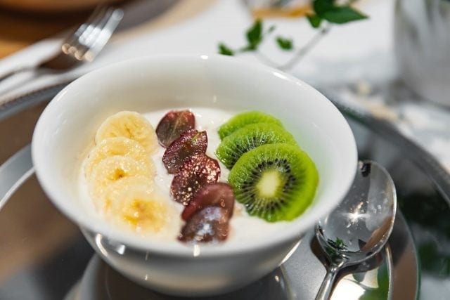 Joghurt mit Bananen, Trauben und Kiwi.