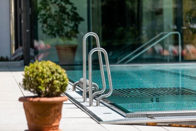Schwimmbad mit Treppe und Pflanzen im Vordergrund