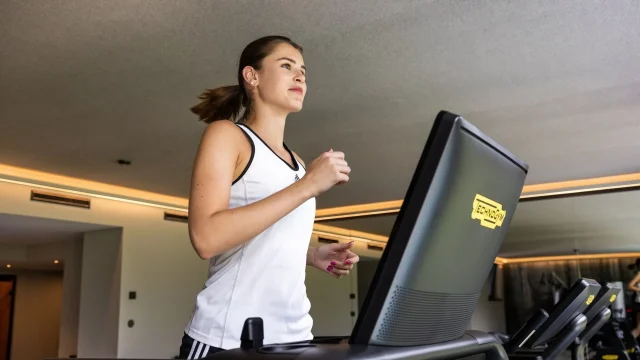 Frau joggt auf dem Laufband im Fitnessstudio