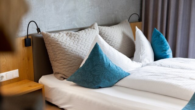 Gemütliches Schlafzimmer mit Kissen und Beleuchtung.