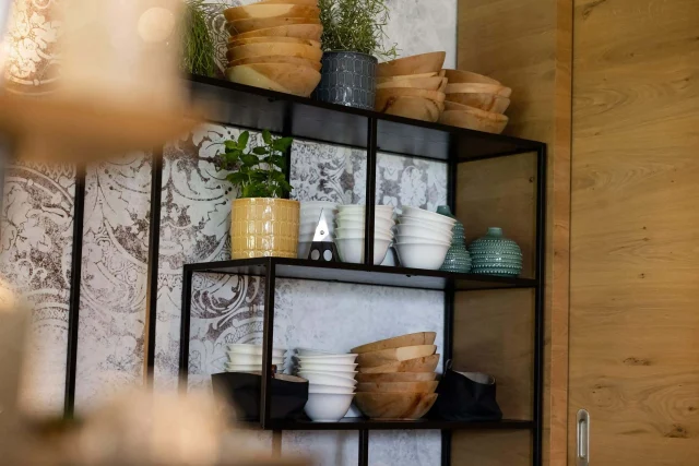 Regal mit verschiedenen Schüsseln und Pflanzen.