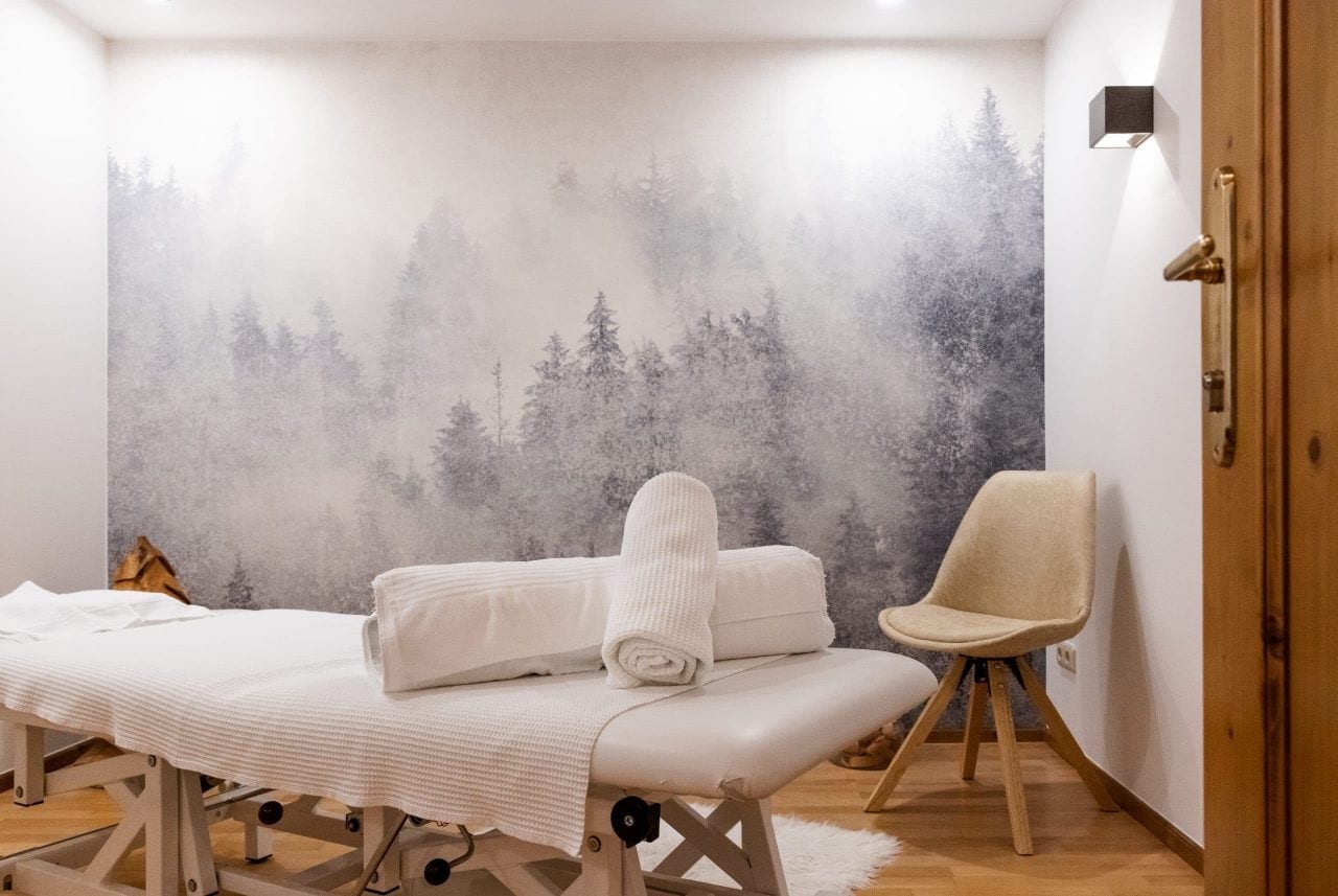 Massagezimmer mit beruhigender Waldtapete.