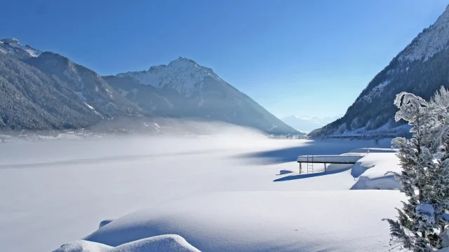 Schneebedeckte Landschaft mit Bergen und See