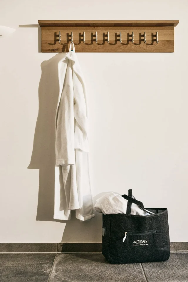 Weißer Bademantel und Tasche an der Wand