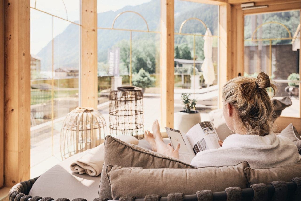 Frau entspannt beim Lesen in heller Umgebung.