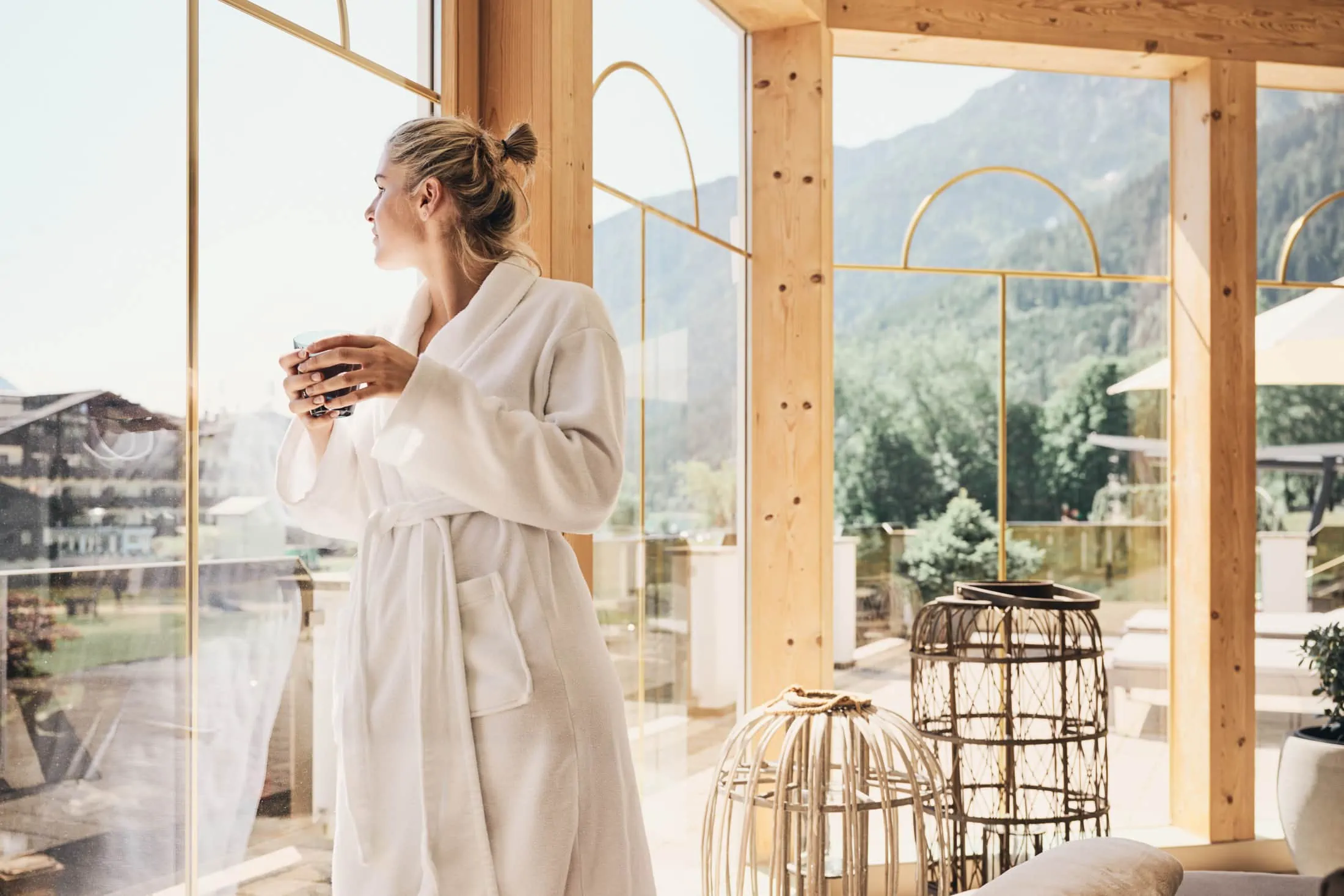 Frau in Morgenmantel genießt den Ausblick