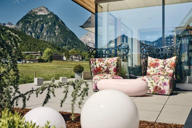 Balkon mit bunten Stühlen und Bergblick