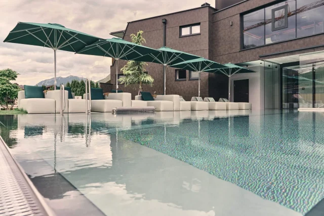 Eleganter Pool mit Sonnenschirmen und Lounge-Möbeln.