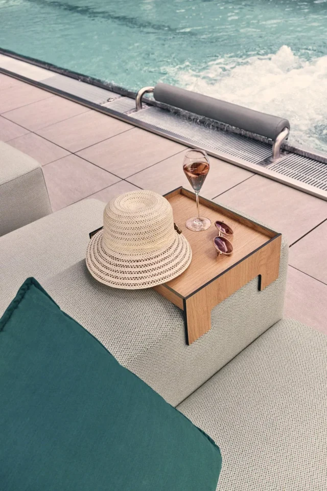 Hut, Glas und Sonnenbrille am Pool.