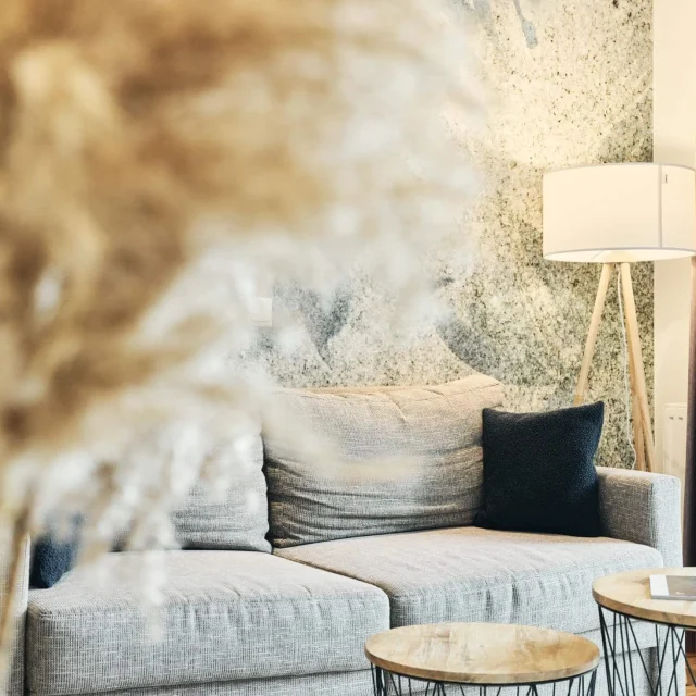 Gemütliches Wohnzimmer mit Sofa und Lampe.