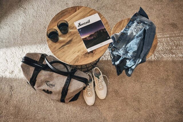 Tasche, Jeansjacke und Getränk auf Tisch