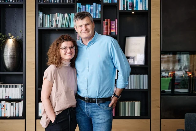 Paar vor Bücherregal lächelnd