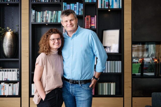 Paar vor Bücherregal lächelnd