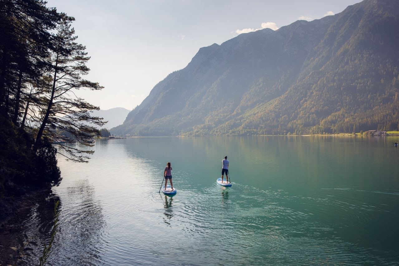 Paddleboarding auf einem ruhigen See in den Bergen