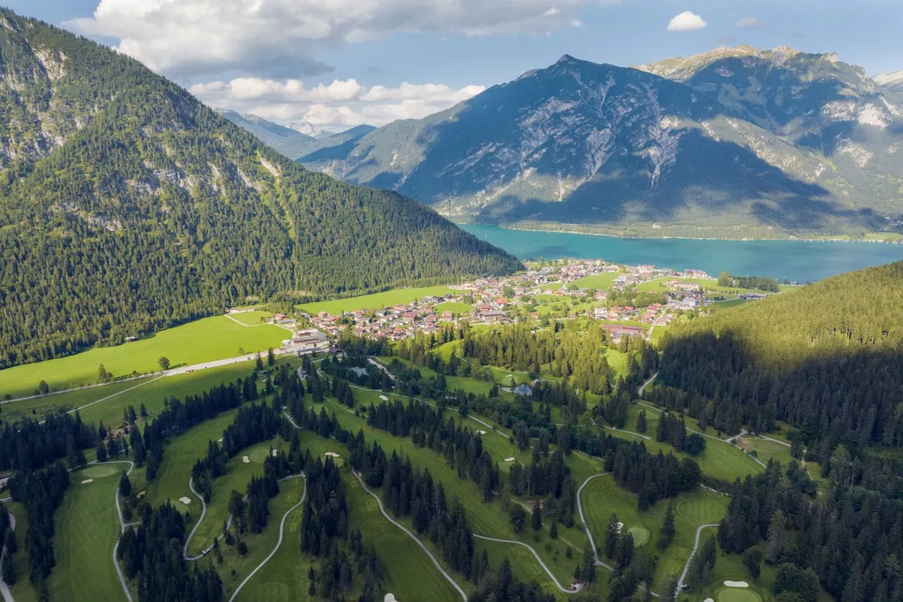 Landschaft mit Bergen, Wäldern und einem Ort