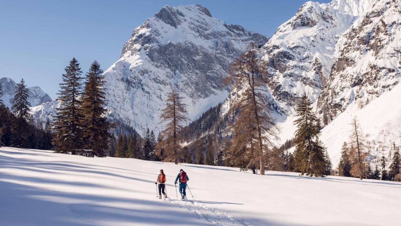 Zwei Personen beim Schneewandern in den Bergen.