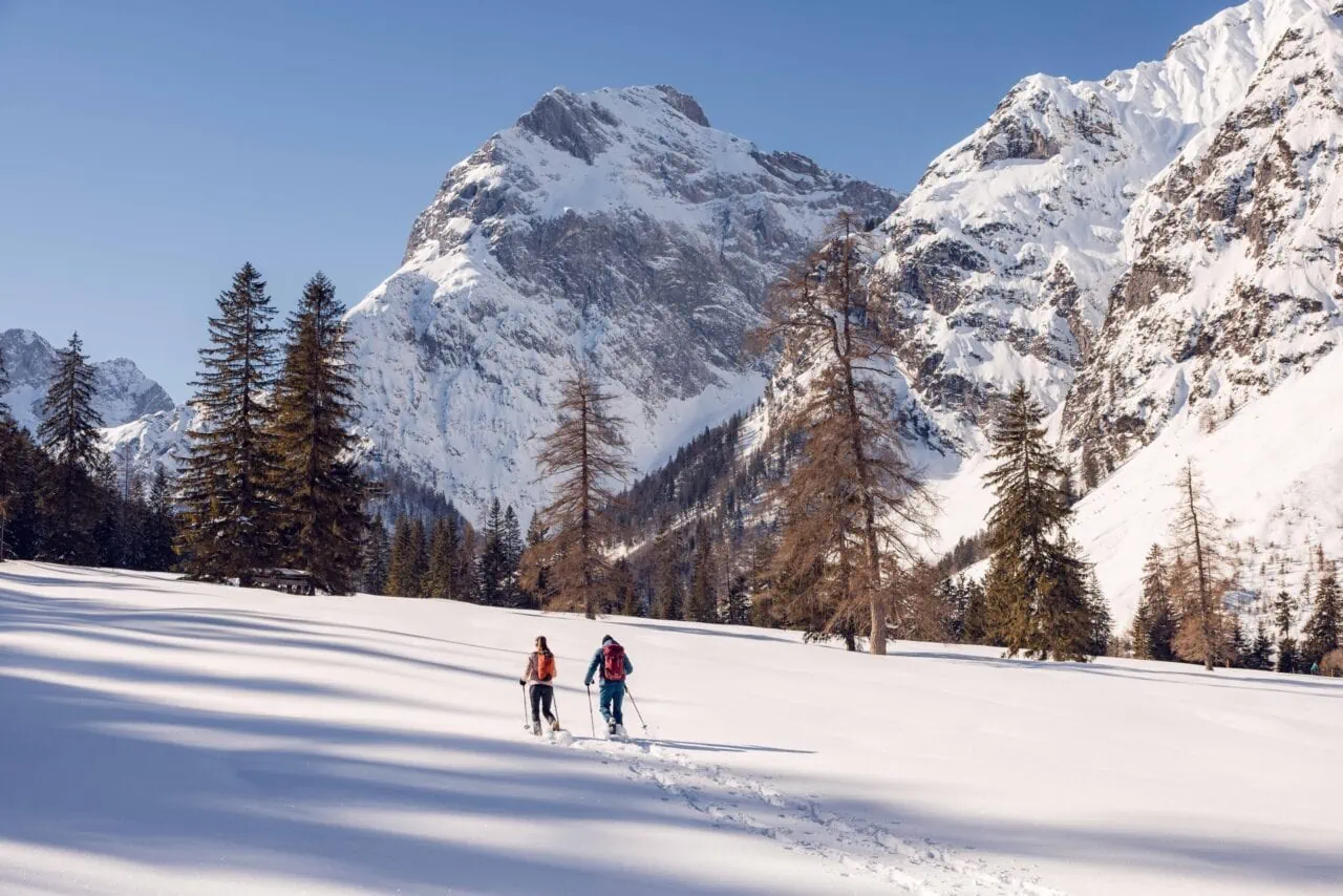 Zwei Personen beim Schneewandern in den Bergen.
