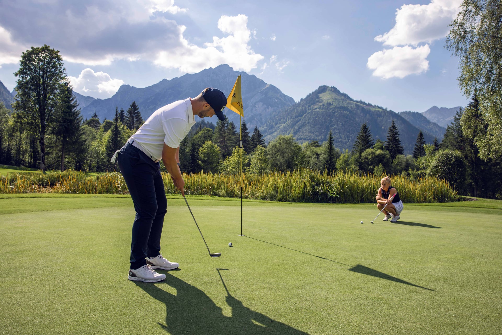 Golfspieler puttet auf einem schönen Platz.