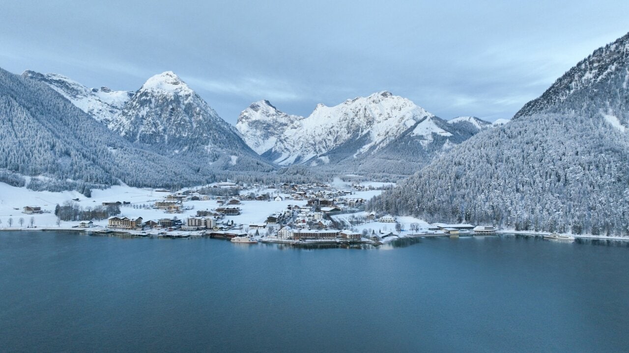 Schneebedeckte Berge und malerisches Dorf am See