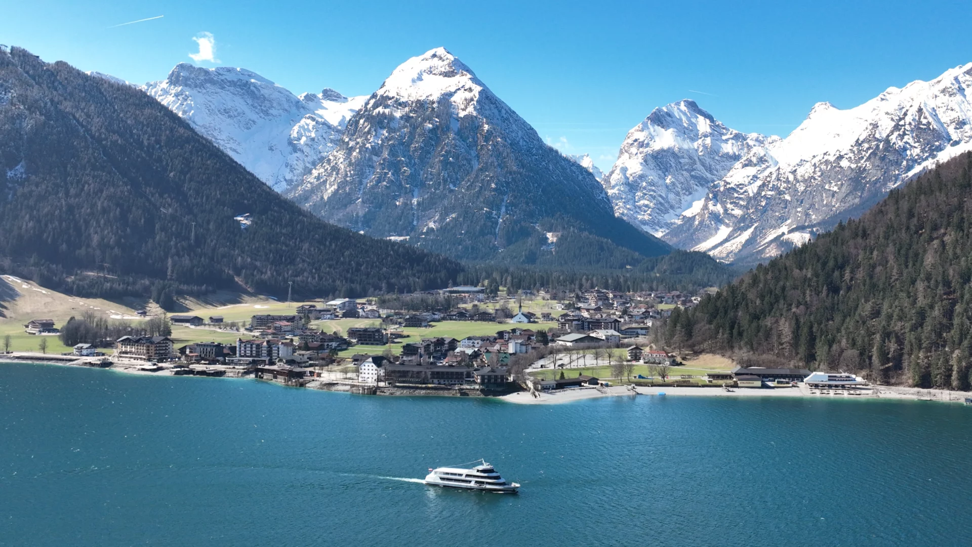 Boot auf klarem Wasser vor den Alpen