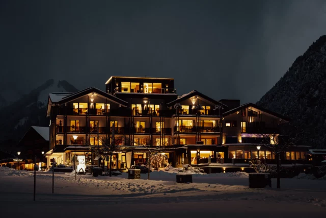 Winterlicher Außenbereich eines beleuchteten Hotels.