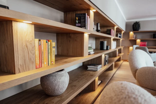Holzregal mit Büchern und dekorativen Objekten.