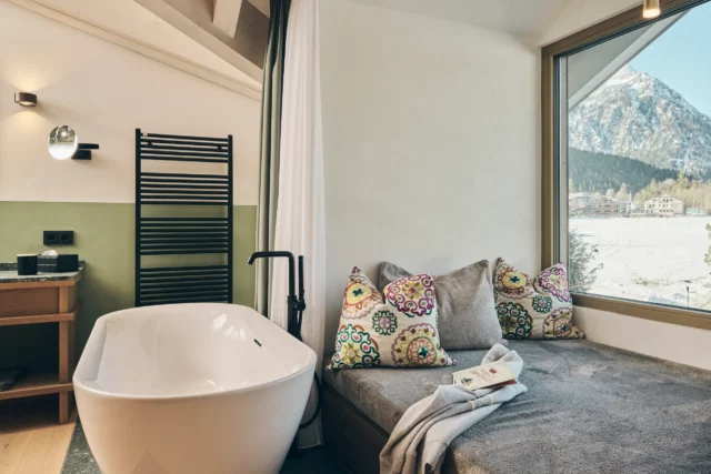 Helles Badezimmer mit Whirlwanne und gemütlichem Sitzbereich.