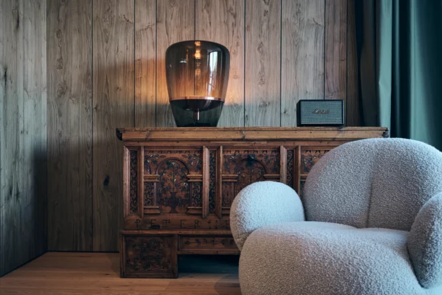 Elegantes Wohnzimmer mit Holzvertäfelung und Lampe.