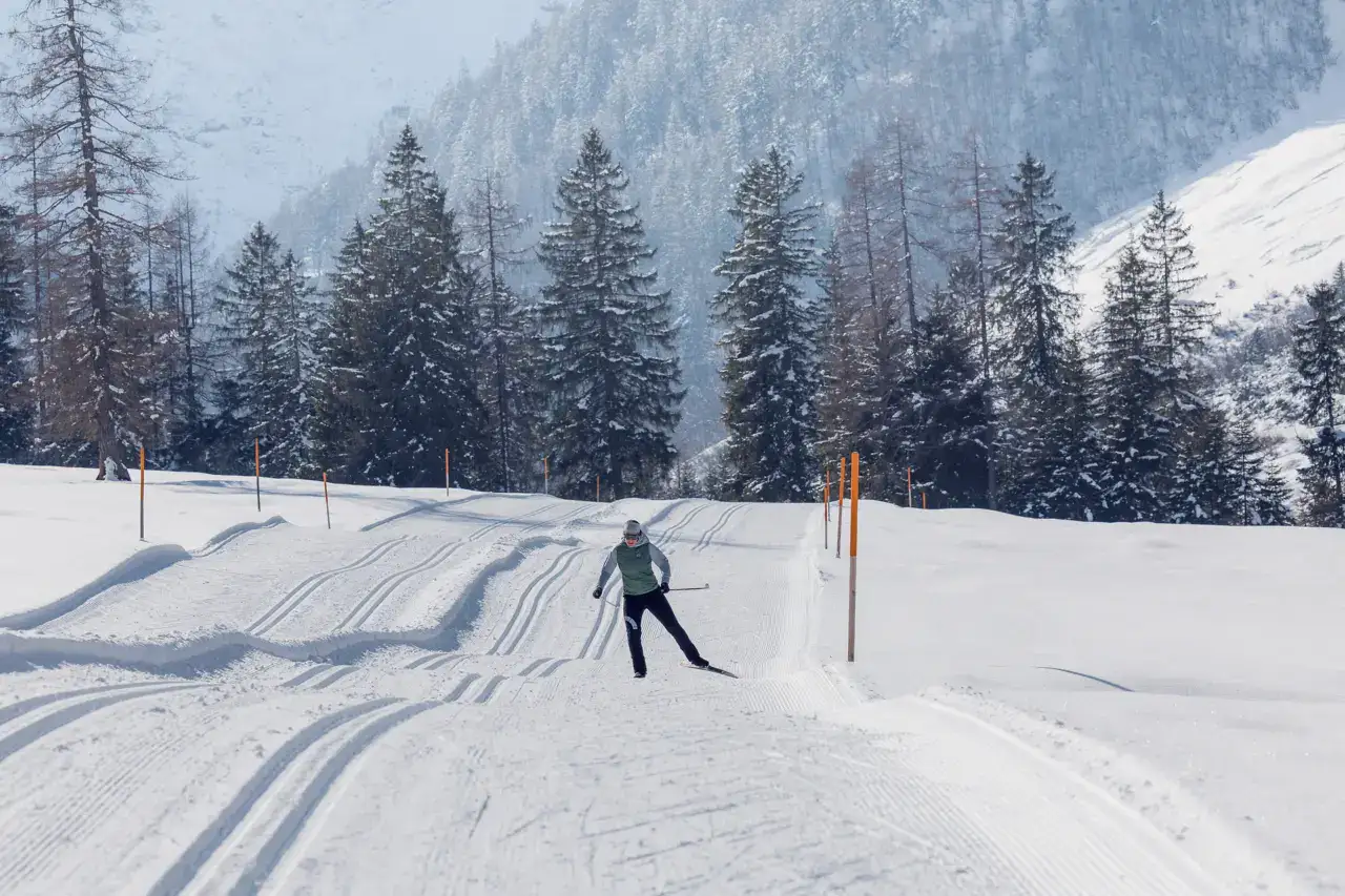 Skifahrer auf schneebedecktem Weg im Wald