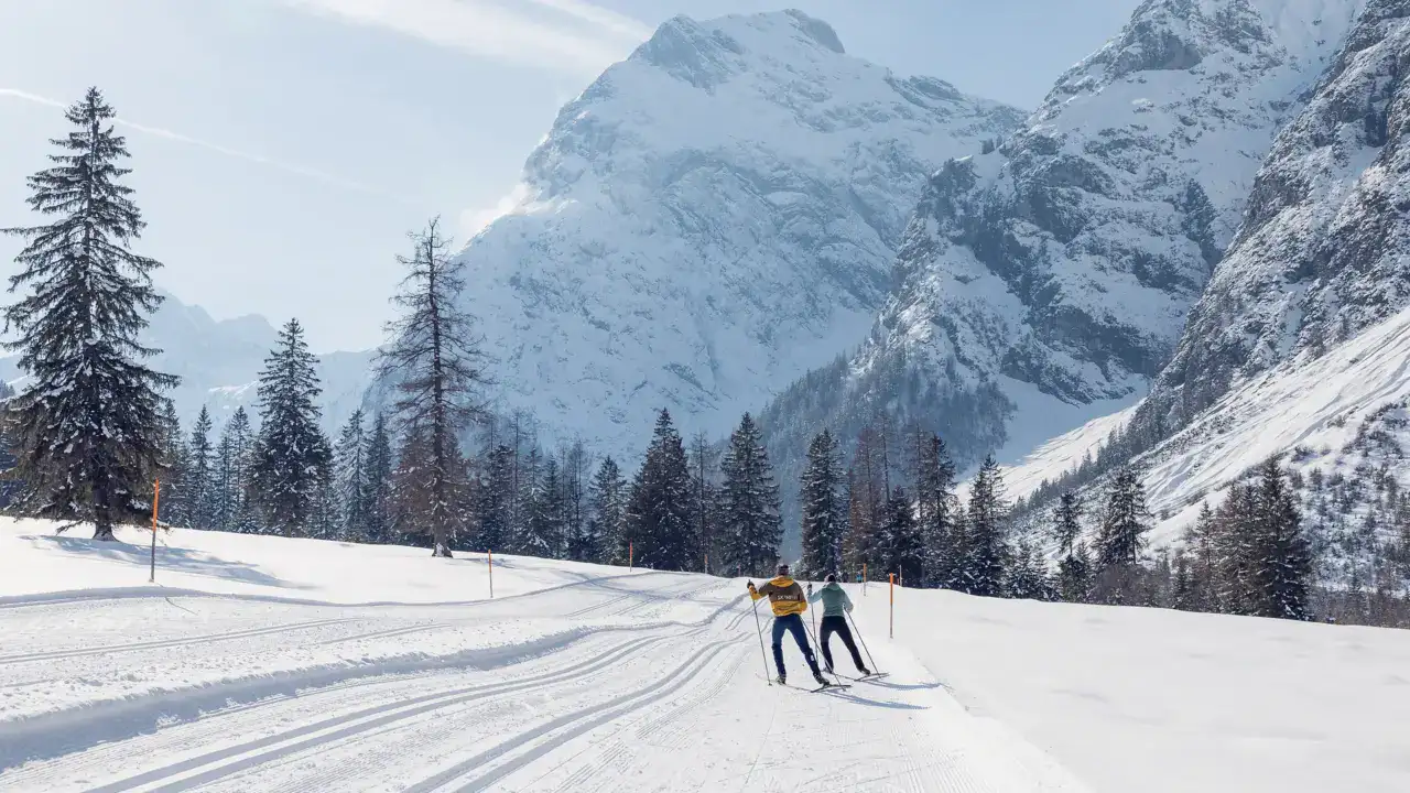 Zwei Personen beim Skilanglauf in verschneiter Landschaft