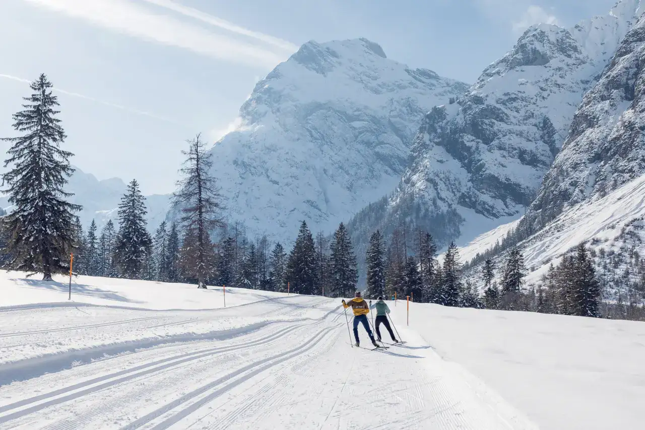 Zwei Personen beim Skilanglauf in verschneiter Landschaft