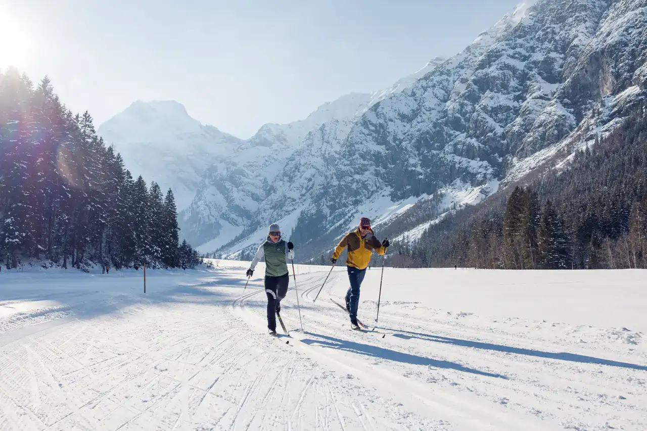 Zwei Personen beim Langlaufen in den Bergen